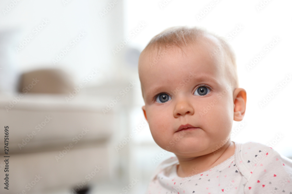 Portrait of cute baby girl in room. Space for text