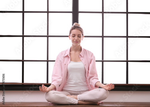 Young woman meditating at home. Zen concept