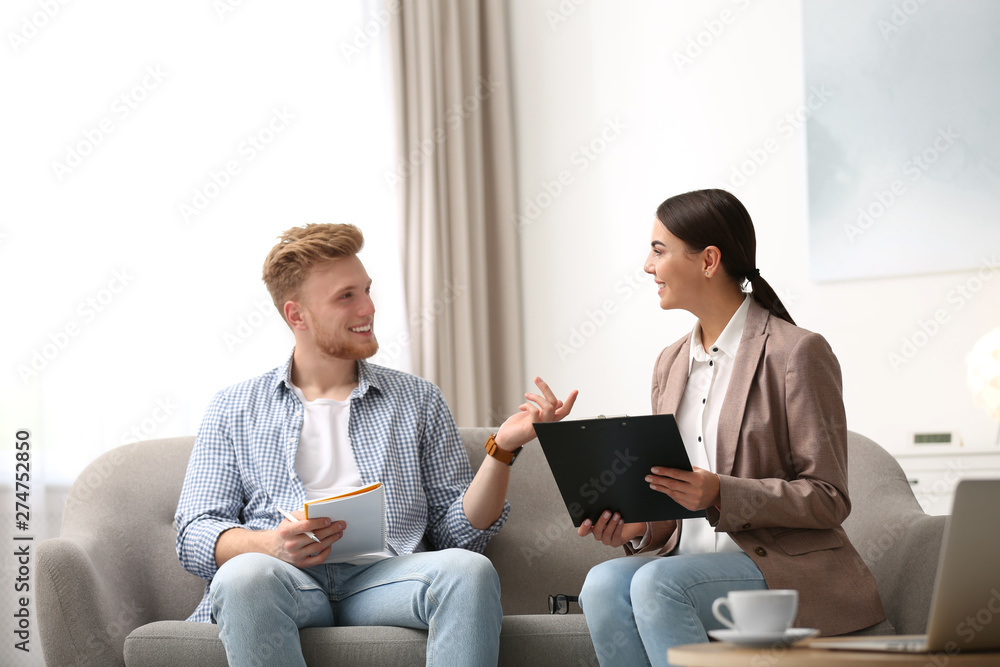 Female insurance agent consulting young man in office Female insurance agent consulting young man in office