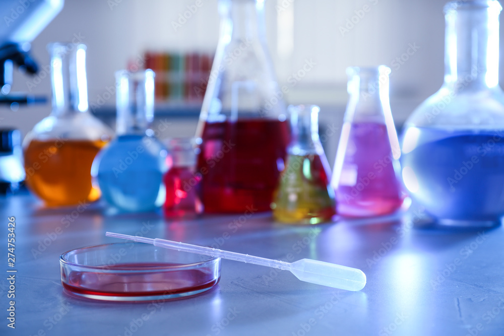 Petri dish with pipette on table against blurred background, space for text. Chemistry glassware Petri dish with pipette on table against blurred background, space for text. Chemistry glassware