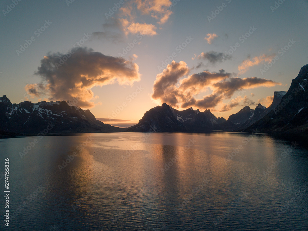 Lofoten islands, Norway reine mountain aerial. Dramatic sunset clouds moving over steep mountain peaks