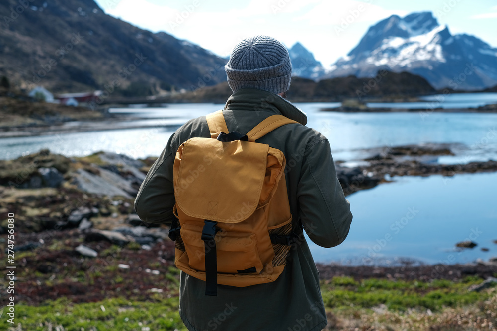 travel and adventure background, hiker with backpack enjoying landscape in Lofoten, Norway travel and adventure background, hiker with backpack enjoying landscape in Lofoten, Norway