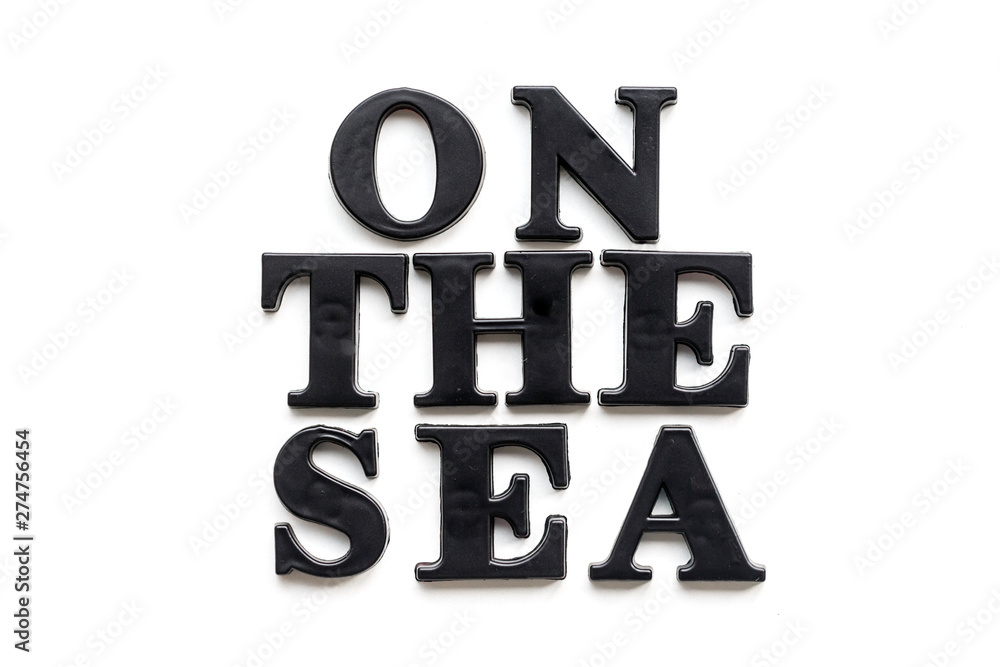 The inscription ON THE SEA. ON THE SEA in black bulk letters on a white background. Photo of the lettering, close-up