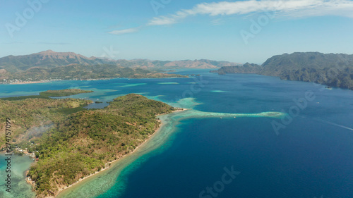 aerial view tropical islands with blue lagoons  coral reef and sandy beach. Palawan  Philippines. Island Busuanga of the Malayan archipelago with turquoise lagoons.