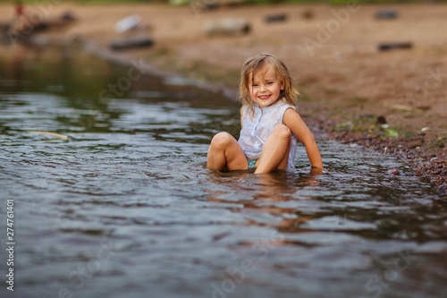 Fototapeta Naklejka Na Ścianę i Meble -  Little girl playing in the lake