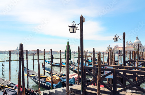 View at Venice lagoon with gondolas and lanterns and San Giorgio Maggiore on background