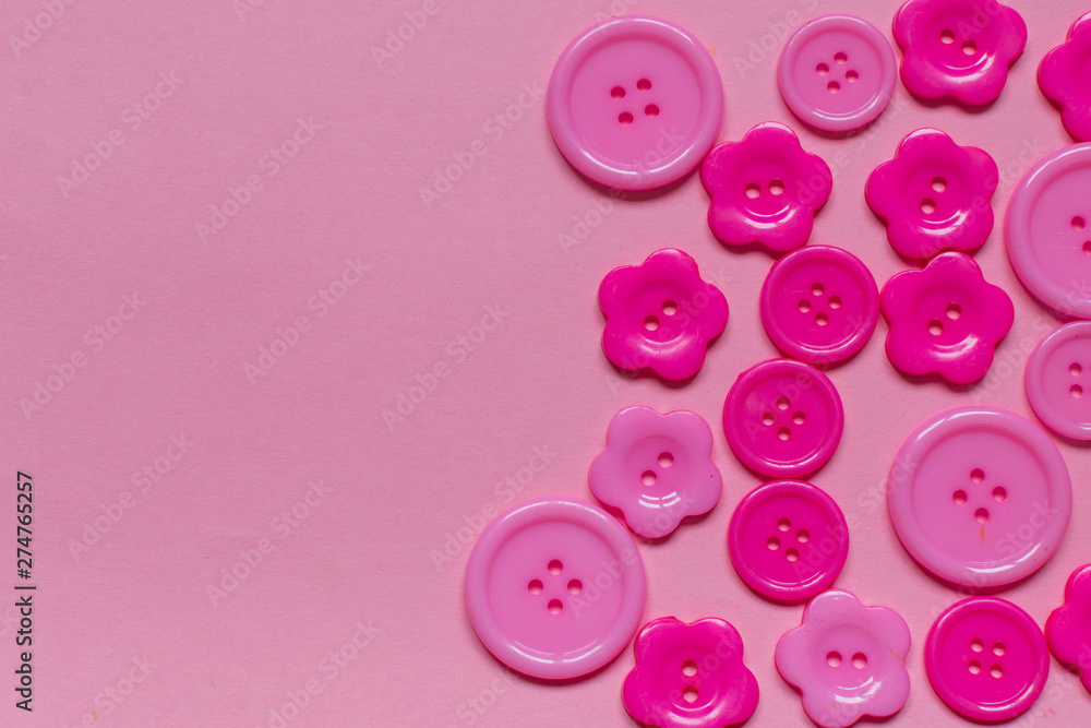 Various pink sewing buttons on light pink background