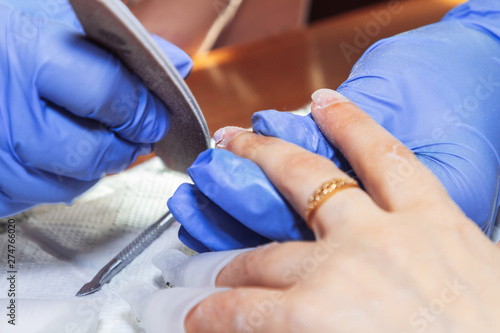 April 28  2019 Minsk Belarus Manicurist processes nails with a scraper for manicure at home