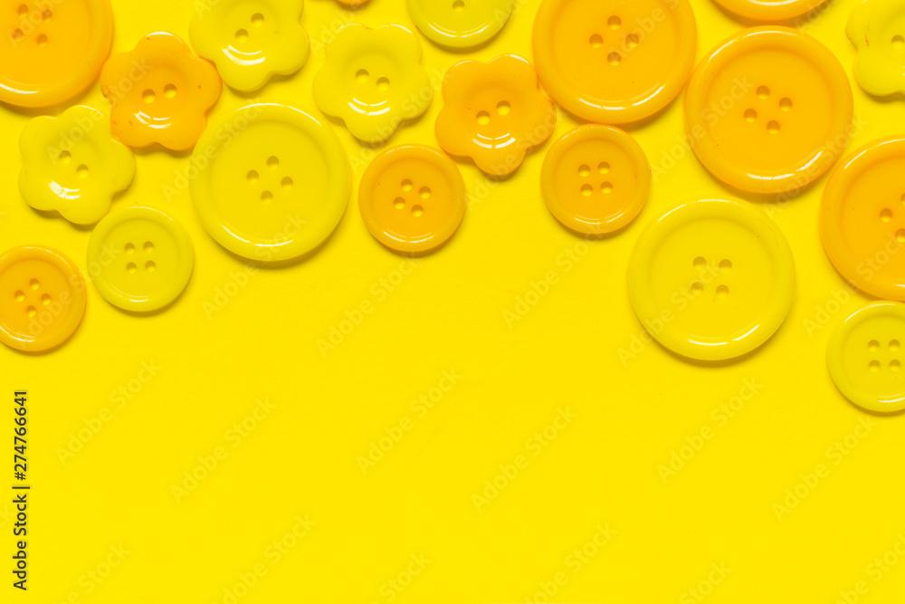 Fototapeta premium Various yellow sewing buttons on yellow background