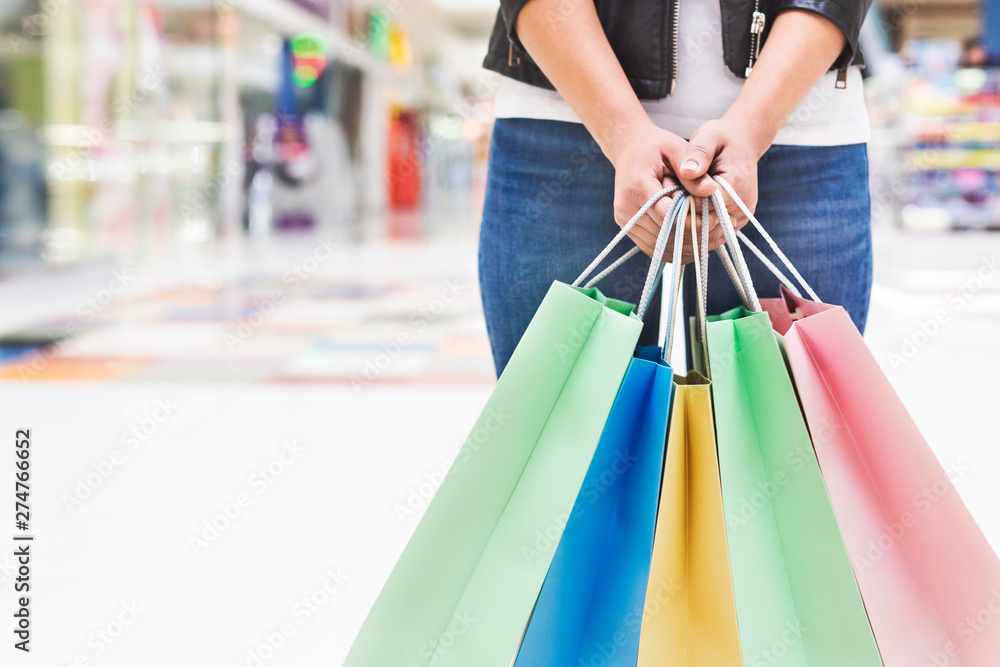 Unrecognizable woman holding shopping bags in central mall