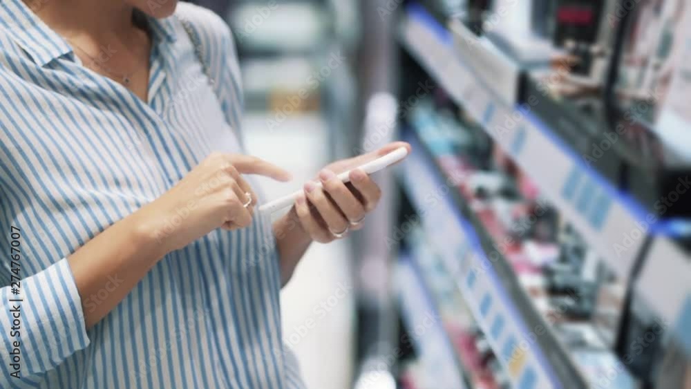 Close up of woman hands uses phone in cosmetic shop, slow motion Close up of woman hands uses phone in cosmetic shop, slow motion
