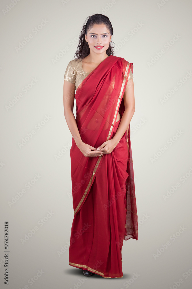 Indian woman wearing a red saree in studio