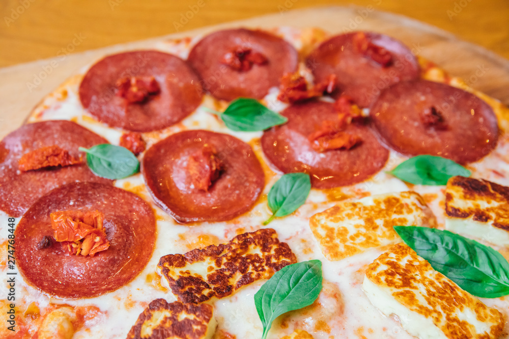 Delicious, fresh and tasty flat bread italian pepperoni or margherita pizza. View of Salami, cheese and basil pizza in restaurant at napoli. Pizza background texture pattern
