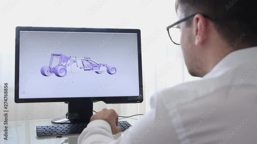 Engineer, Constructor, Designer, Architect in Glasses Working on a Personal Computer. He Creating New Component of BAGGI in CAD Program. Freelance Work Engineer, Constructor, Designer, Architect in Glasses Working on a Personal Computer. He Creating New Component of BAGGI in CAD Program. Freelance Work