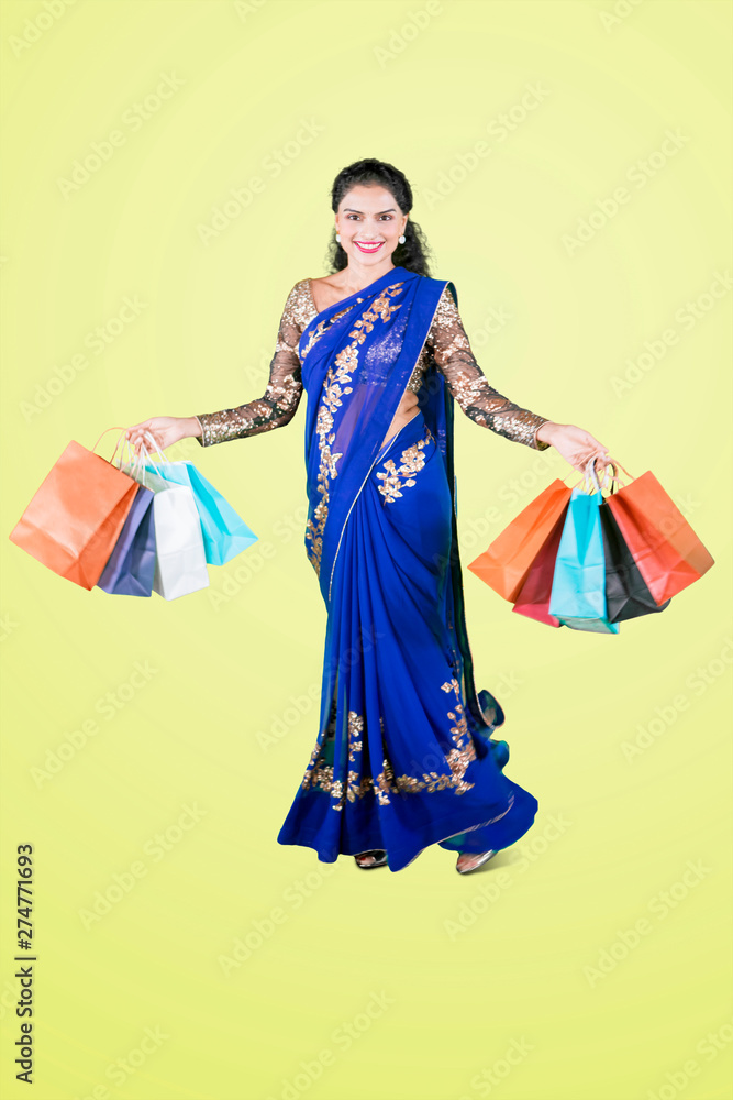 Pretty Indian girl carries shopping bags on studio
