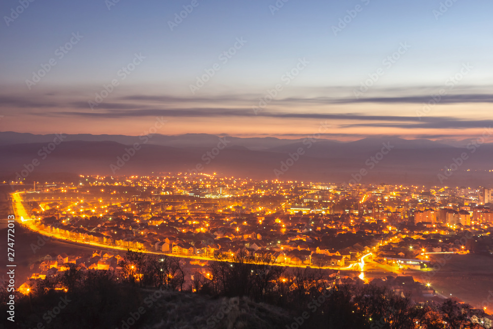 Stunning late blue hour view of Pirot cityscape with hot city lights and colorful sky