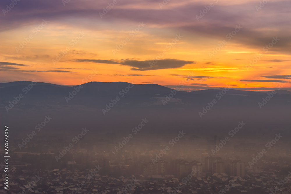 Beautiful view of misty Pirot cityscape covered by first winter snow and stunning blue hour colors in the sky Beautiful view of misty Pirot cityscape covered by first winter snow and stunning blue hour colors in the sky