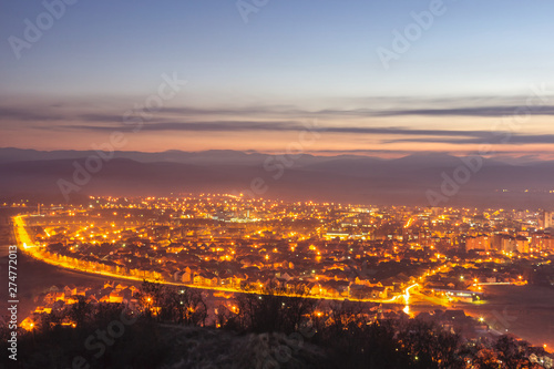 Stunning late blue hour view of Pirot cityscape with hot city lights and colorful sky