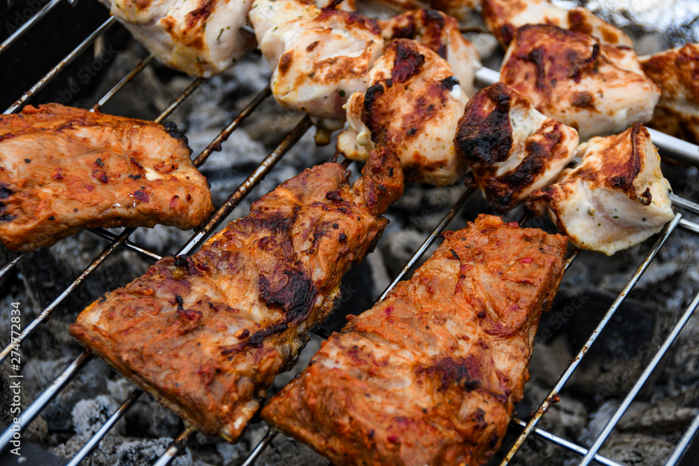 Juicy Pork steak, ribs and chicken meat on bbq grill, homemade barbecue, closeup.