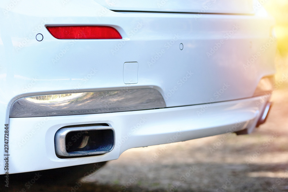 Fototapeta premium Selective focus on parking sensor exhaust pipe bumper at rear of white luxurious car bumper close up