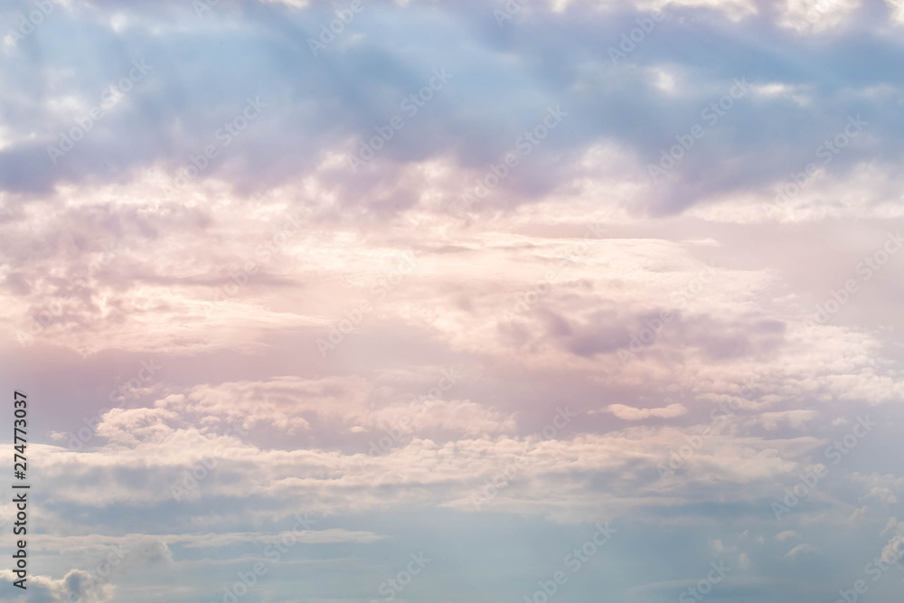 The sunset sky in cloudy weather. Through layers of clouds looks through the sun, the central part of clouds is painted in red color The sunset sky in cloudy weather. Through layers of clouds looks through the sun, the central part of clouds is painted in red color