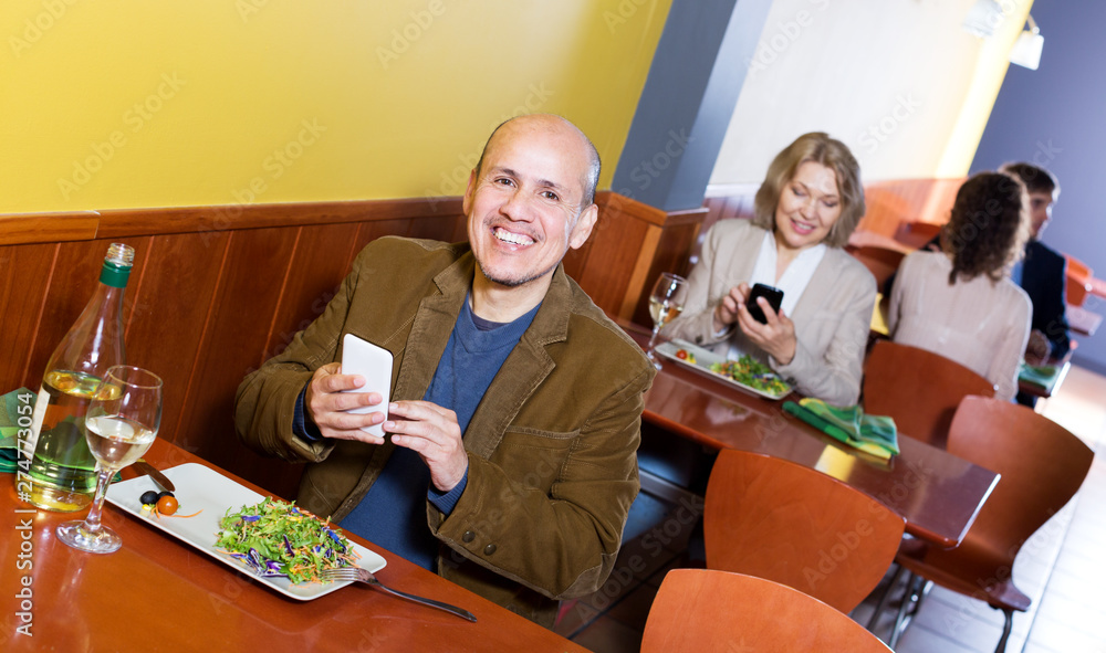 Senior male businessman with food and smartphone
