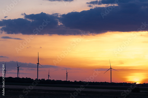 Wind turbines at sunset. Six wind turbines on the background of a beautiful sky.