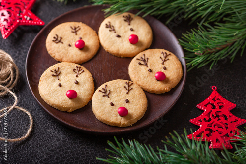 Homemade deer cookies decorated chocolate and red candies Soft focus Greeting card © lizaelesina