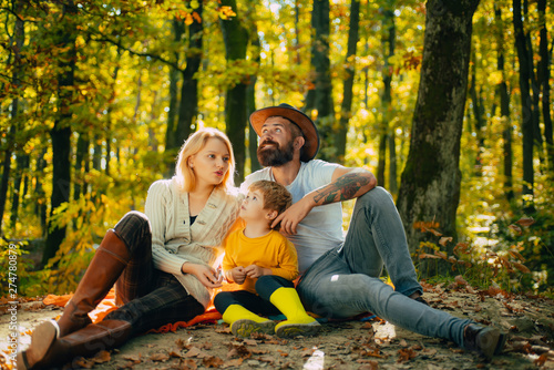 Picnic in nature. United with nature. Family day concept. Happy family with kid boy relaxing while hiking in forest. Basket picnic healthy food snacks fruits. Mother father and small son picnic
