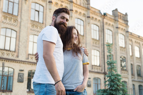 Happy together. Couple in love walking having fun. Tender hug. Couple relaxing enjoying each other. Hipster and pretty woman in love stand in street architecture building background. Feel my love