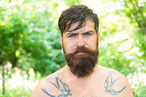 Summer heat. Bearded tattooed guy relax in nature hot summer day. Hipster wet skin and hair survive heat. Vacation resort. Extreme heat. Man thirsty sweaty hipster naked in forest. Heat concept