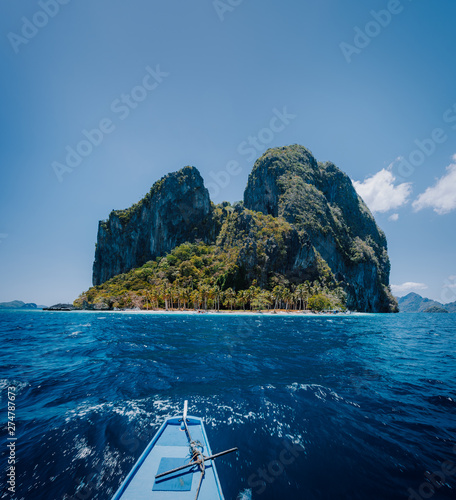 Philippino local boat facing impressive tropical Pinagbuyutan Island. El Nido, Palawan, Philippines photo