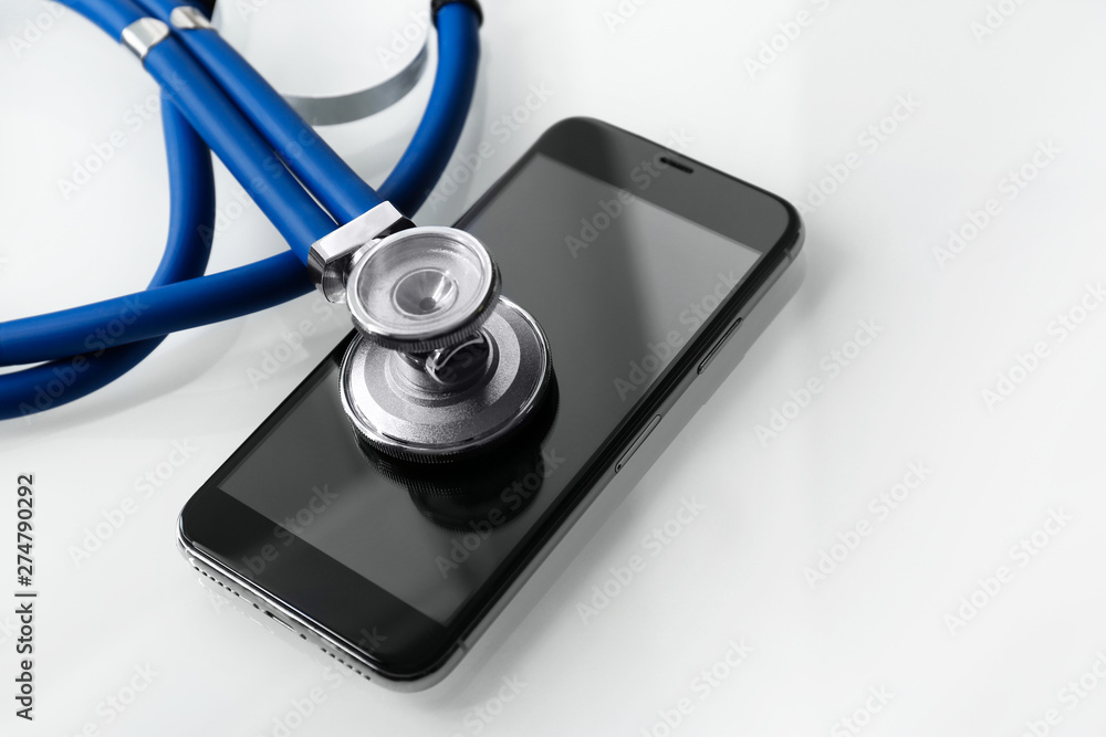 Smartphone and stethoscope on light table, closeup with space for text. Repairing service Smartphone and stethoscope on light table, closeup with space for text. Repairing service