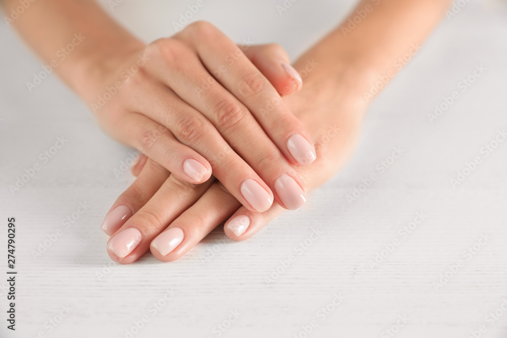 Closeup view of woman with smooth hands and manicure at table, space for text. Spa treatment