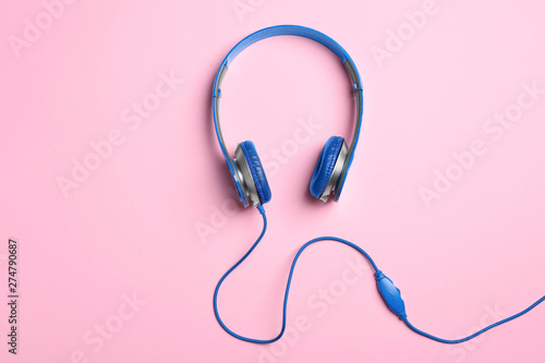 Stylish headphones on color background, top view