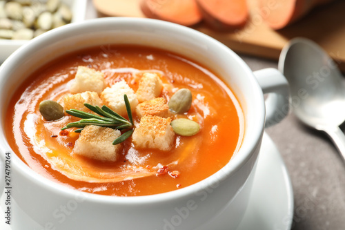 Bowl of tasty sweet potato soup on table, closeup. Space for text