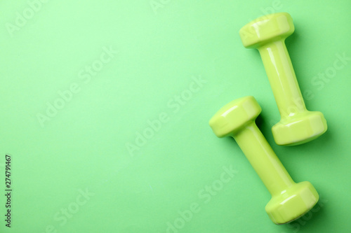 Bright dumbbells and space for text on color background, flat lay. Home fitness