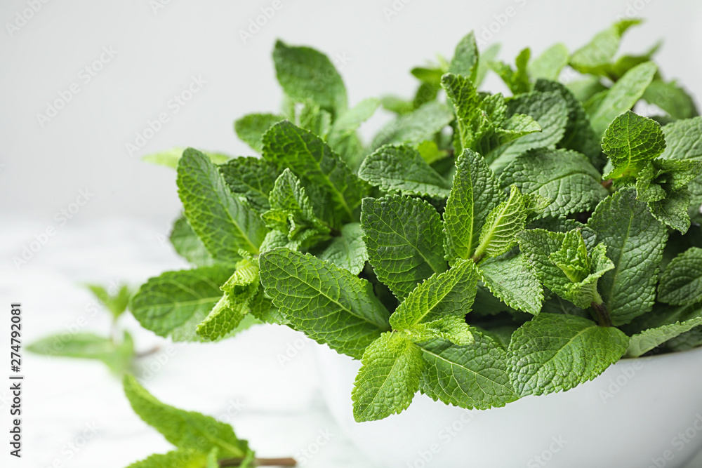 Bowl with fresh green mint on table, closeup Bowl with fresh green mint on table, closeup