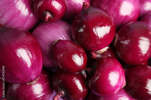 Pile of fresh red onions as background, closeup