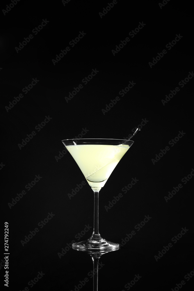 Glass of delicious cucumber martini on dark background