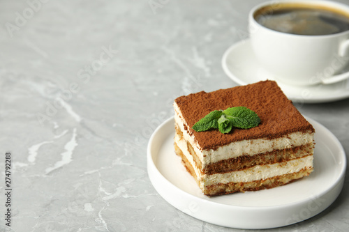 Tiramisu cake with cup on table, space for text