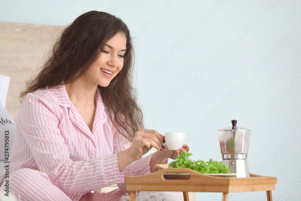 Beautiful young woman having breakfast in bed Beautiful young woman having breakfast in bed