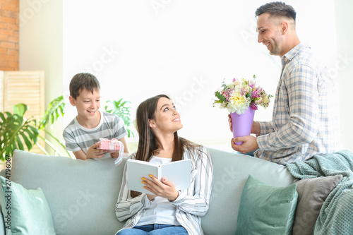 Family greeting young woman...