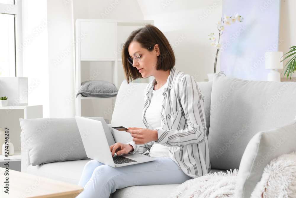 Young woman with credit card and laptop shopping online at home Young woman with credit card and laptop shopping online at home