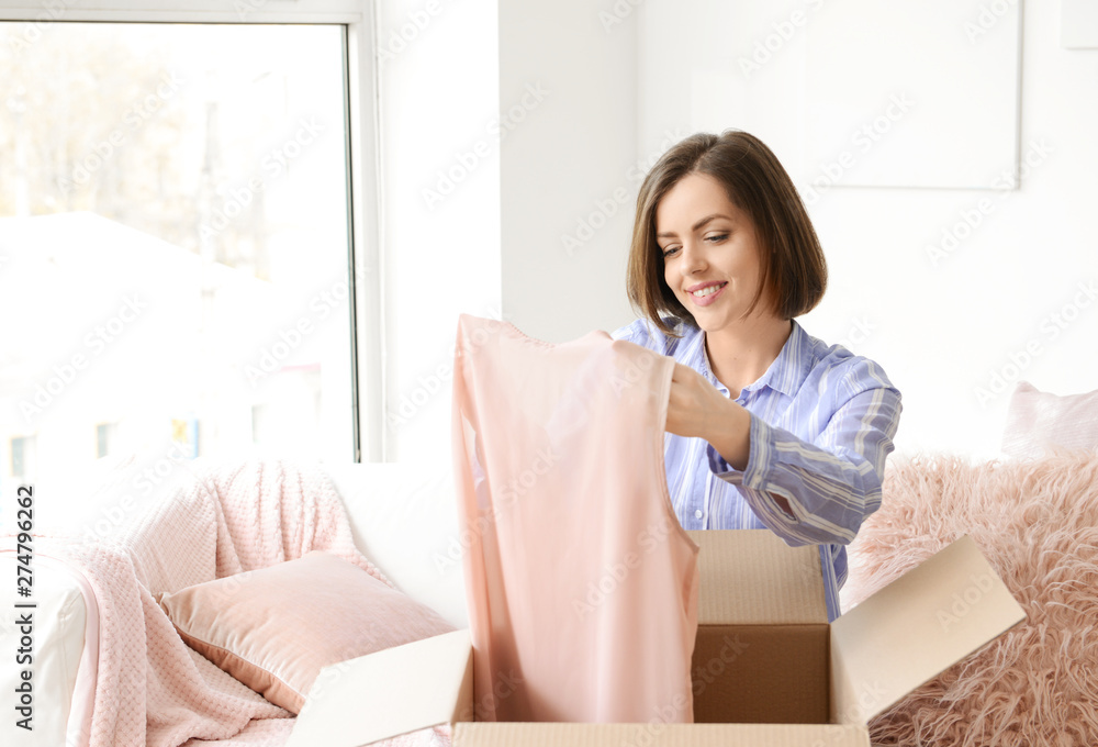 Young woman opening parcel with new purchase at home Young woman opening parcel with new purchase at home