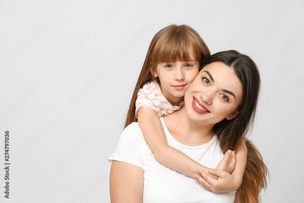 Portrait of happy mother and daughter on light background Portrait of happy mother and daughter on light background