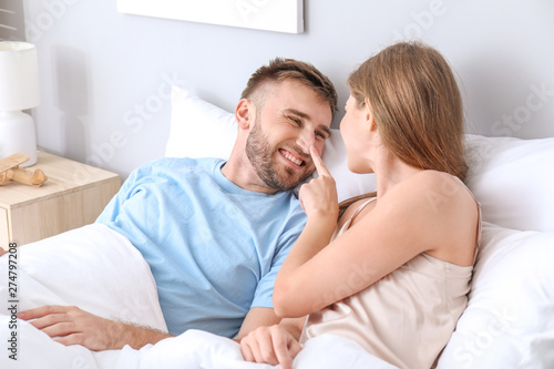 Portrait of happy young couple in bedroom