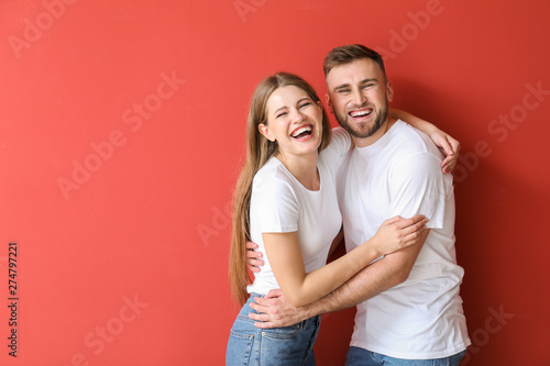 Portrait of happy young couple on color background