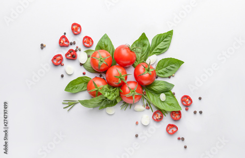 Fresh basil, tomato and spices on light background