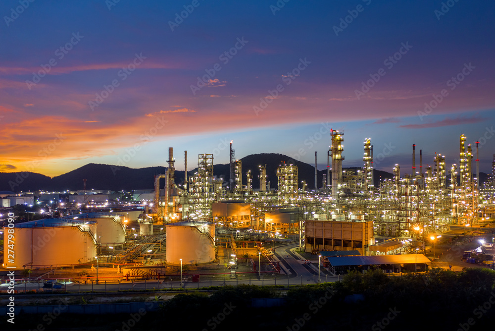 Obraz premium Aerial view. Oil refinery factory and oil storage tank at twilight and night. Petrochemical Industrial.